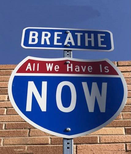 Street sign that said "Breathe- All We Have is Now"